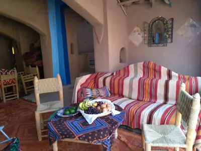 a living room with a couch and a bowl of fruit on a table at Camp Iguidi Tours in Mhamid