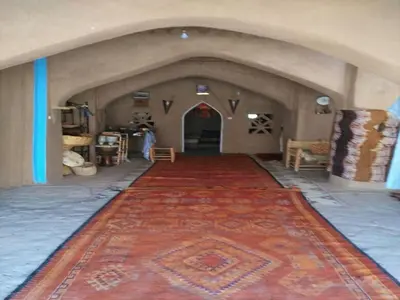 a hallway with a red rug on the floor in a building at Camp Iguidi Tours in Mhamid