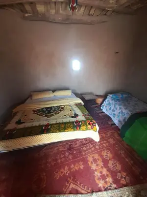 a bedroom with two beds in a room at Camp Iguidi Tours in Mhamid