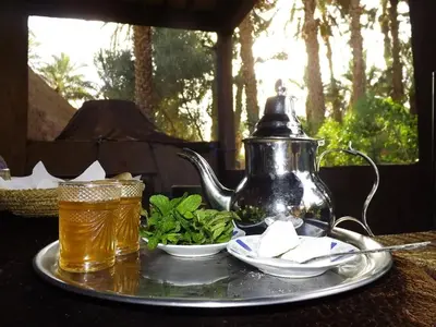 a tray with a tea kettle and a plate of food at Ecolodge du Draa in Ouled Otmane
