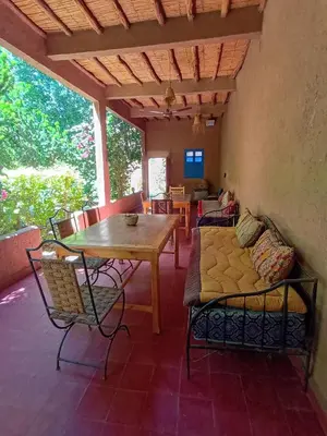 a living room with a table and chairs and a couch at Ecolodge du Draa in Ouled Otmane