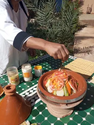 a person preparing a dish of food on a table at Ecolodge du Draa in Ouled Otmane
