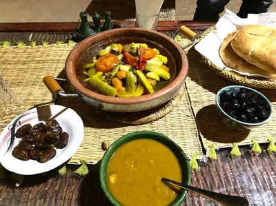 a table with a bowl of soup and a bowl of food at Ecolodge du Draa in Ouled Otmane