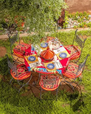 a table with four chairs and a tea pot on it at Dar Soulaimane in Marrakech