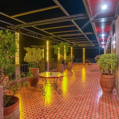 a patio with a table and potted plants in a building at Dar Soulaimane in Marrakech