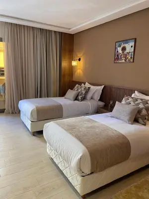 a hotel room with two beds in a room at Hotel De Nice in Meknès