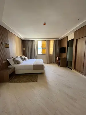 a large bedroom with a bed and a desk at Hotel De Nice in Meknès