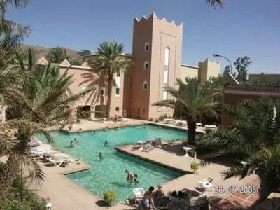 a large swimming pool with people in a resort at Hôtel Le Tinsouline in Zagora