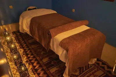 two beds in a blue room with a rug at Hotel Kasbah Azalay in Mhamid