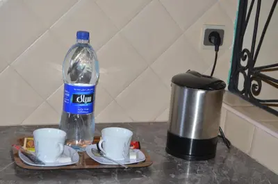 a bottle of water sitting on a tray with two cups at Hotel Azoul in Ouarzazate