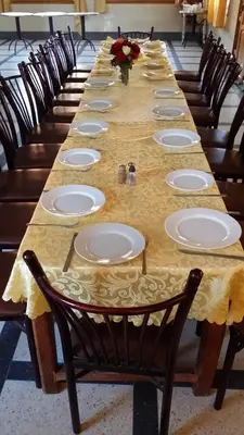 a long table with chairs and plates on it at Hotel Mandar Saghrou Tazakhte in Kalaat MGouna