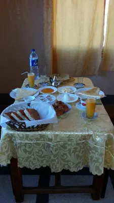 a table with plates of food and drinks on it at Hotel Mandar Saghrou Tazakhte in Kalaat MGouna