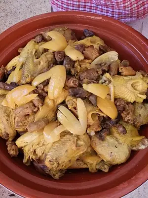 a red bowl of food with meat and onions at Hotel Mandar Saghrou Tazakhte in Kalaat MGouna
