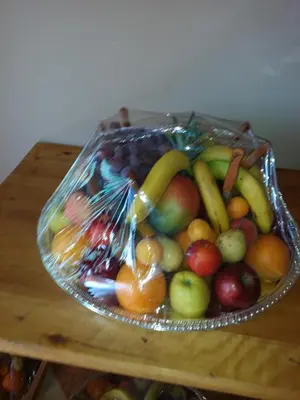 a glass bowl of fruit on a wooden table at Hotel Mandar Saghrou Tazakhte in Kalaat MGouna