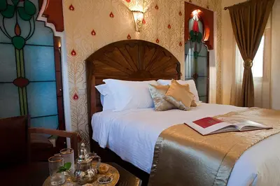 a bedroom with a bed with a book on it at Le Temple Des Arts in Ouarzazate