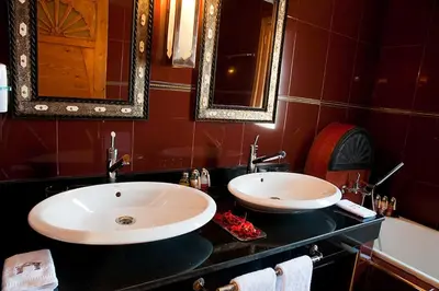 a bathroom with two sinks and a mirror and a tub at Le Temple Des Arts in Ouarzazate
