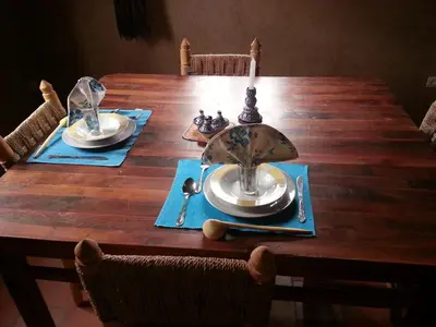 a wooden table with plates and dishes on it at Les 4 Saisons Du Dades in Aït Idaïr