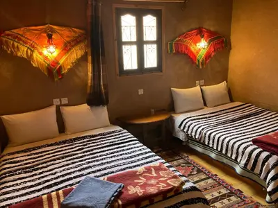 a room with two beds and a window at Les 4 Saisons Du Dades in Aït Idaïr