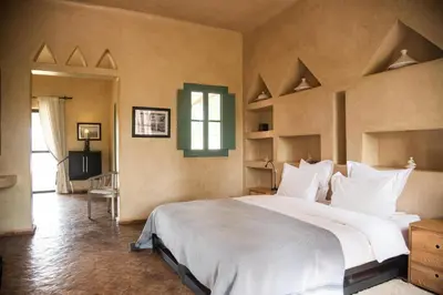 a large bedroom with a large bed with white pillows at Jnane Allia in Douar Soukkane