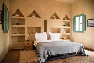 a bedroom with a large bed with white pillows at Jnane Allia in Douar Soukkane