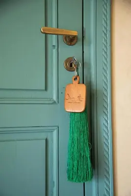 a green tassel hanging on a door with a tag at Jnane Allia in Douar Soukkane