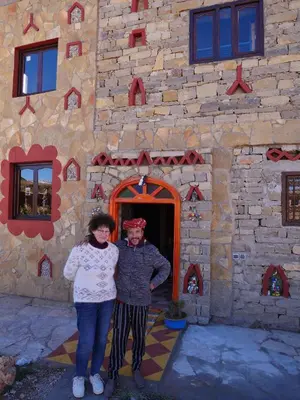 a man and a woman standing in front of a building at Auberge Hostel Traditionnel in Tinerhir