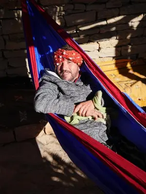 a man is sleeping in a hammock at Auberge Hostel Traditionnel in Tinerhir