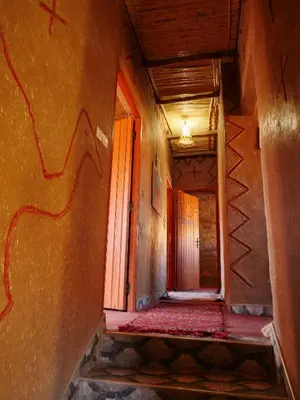 an empty hallway with a stairway with a red line on the wall at Auberge Hostel Traditionnel in Tinerhir