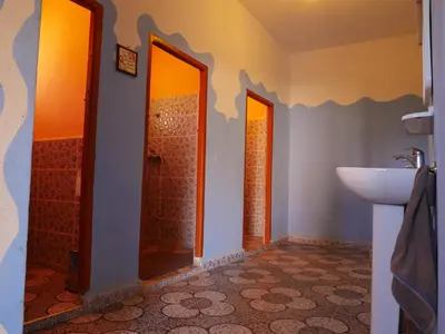 a bathroom with two doors and a sink at Auberge Hostel Traditionnel in Tinerhir