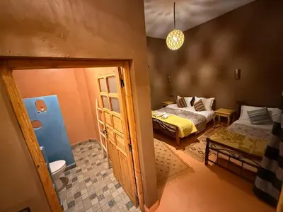 a small room with two beds and a bathroom at Dar Talhaya in Kasr Bounou