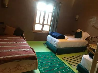 a bedroom with two beds and a window at Dar Talhaya in Kasr Bounou