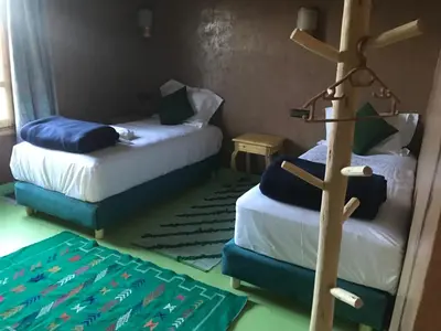 a room with two beds and a cross on the floor at Dar Talhaya in Kasr Bounou