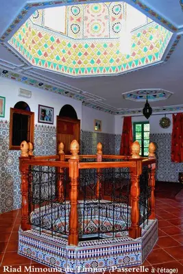 a living room with a ceiling with a mosaic at Riad Mimouna De Timnay in Aguelmous