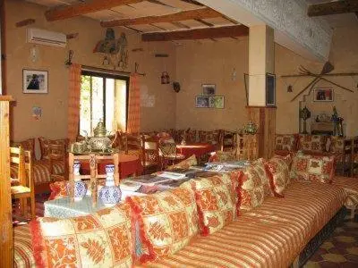 a living room with a couch and a table at Riad Mimouna De Timnay in Aguelmous