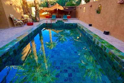 a swimming pool with trees in the middle of it at Dar Sofar in Agdz