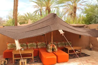 a couch under an umbrella on a patio at Dar Sofar in Agdz