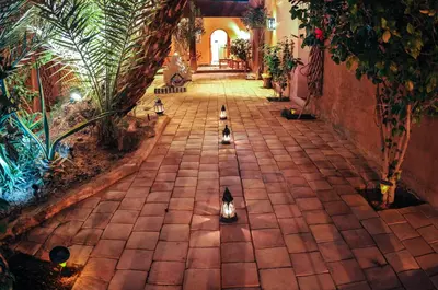 a hallway with pigeons walking down a brick walkway at Dar Sofar in Agdz