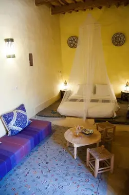 a room with a bed and a couch and a table at Dar Sofar in Agdz