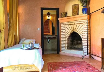 a bedroom with a fireplace and a bed in a room at Riad Sidi Hicham in Marrakech