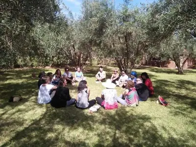 a group of people sitting in the grass at Riad Sidi Hicham in Marrakech