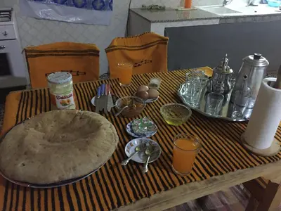 a wooden table with a table cloth with a table sidx sidx at Gîte d'étape traditionnel berbère in Ifri