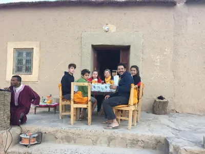 a group of people sitting around a table at Gîte d'étape traditionnel berbère in Ifri