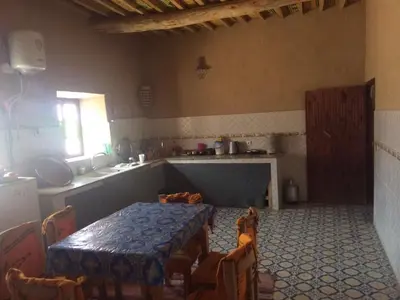 a room with a table and chairs in a kitchen at Gîte d'étape traditionnel berbère in Ifri