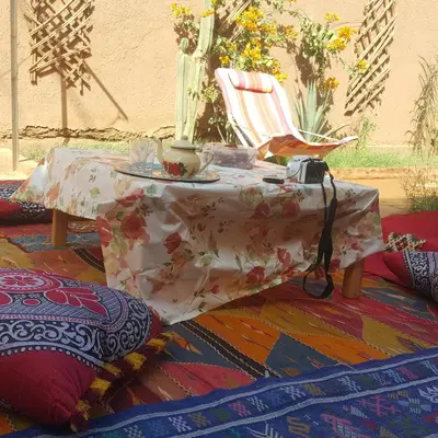 a table and a chair with a table and a table at Authentic riad & activities Erg in Mhamid