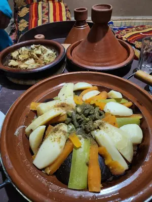 a plate of food on a table with vegetables at Authentic riad & activities Erg in Mhamid