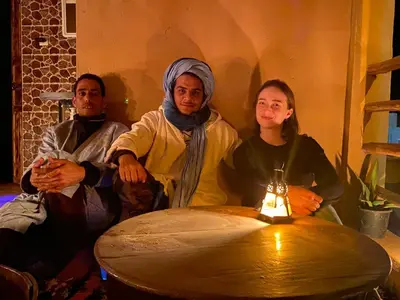 a group of three people sitting around a table at Authentic riad & activities Erg in Mhamid