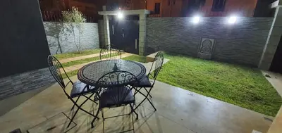 a patio table and chairs with a yard at night at Villa Nour in Fès