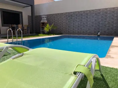 a swimming pool with a chaise lounge and a swimming pool at Villa Nour in Fès