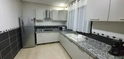 a small kitchen with white cabinets and a refrigerator at Villa Nour in Fès