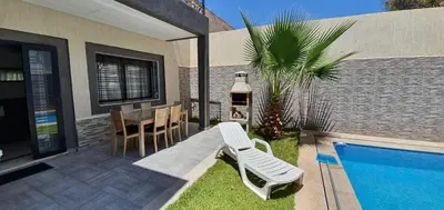 a patio with a table and chairs and a pool at Villa Nour in Fès
